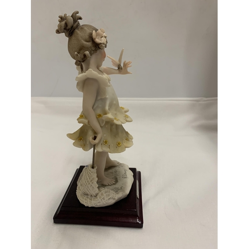 787A - A 1986 FLORENCE FIGURE OF A GIRL HOLDING A BUTTERFLY, SIGNED G.ARMANI