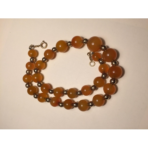 534A - A MARKED 9 CARAT GOLD AND MILK AMBER GOLD NECKLACE WITH A PRESENTATION BOX