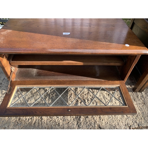 3026 - AN OAK TV STAND WITH GLAZED AND LEADED DOOR, 31