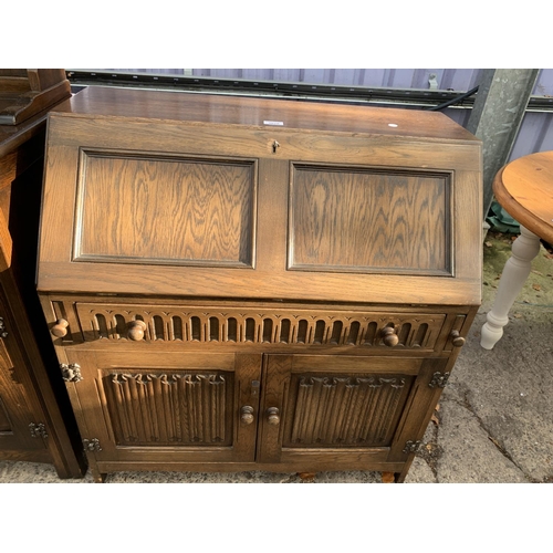 3028 - A MODERN OAK BUREAU WITH LINENFOLD DOORS TO THE BASE, 33