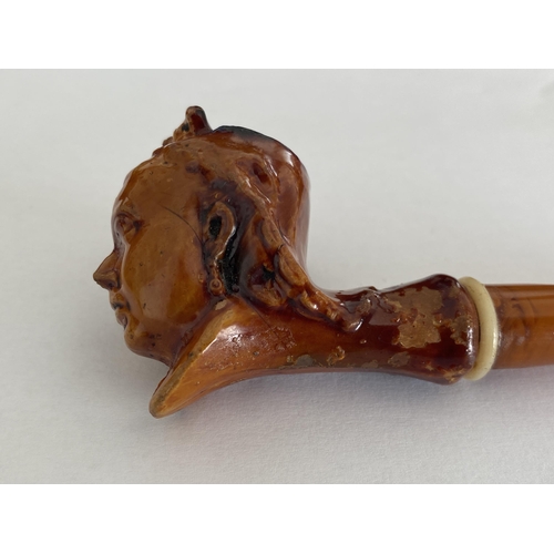 52 - AN ANTIQUE BRITISH QUEEN VICTORIA TREACLE GLAZE TOBACCO PIPE WITH AMBER EFFECT PIPE, LENGTH 13 CM