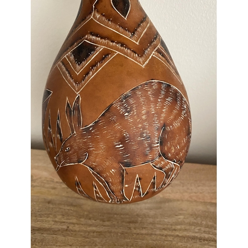 59 - A VINTAGE AFRICAN TRIBAL GOURD WITH AARDVARK AND BUTTERFLY DESIGN, HEIGHT 29.5 CM