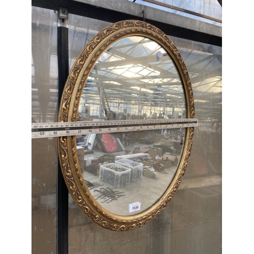 1530 - A DECORATIVE OVAL GILT FRAMED WALL MIRROR