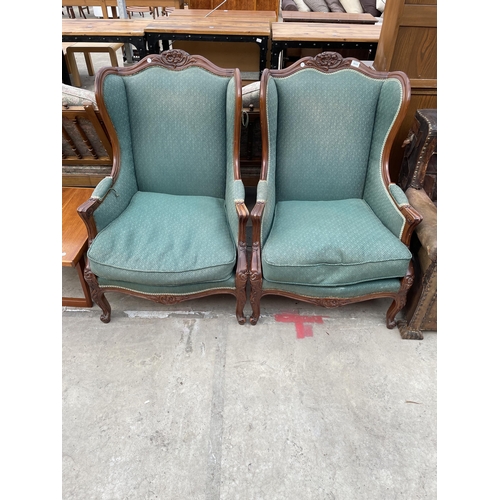 2535 - A PAIR OF MAHOGANY FRAMED VICTORIAN STYLE WINGED FIRESIDE CHAIRS WITH FOLIATE CARVING