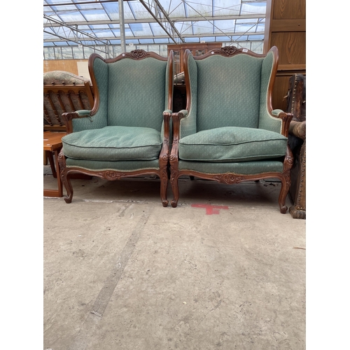 2535 - A PAIR OF MAHOGANY FRAMED VICTORIAN STYLE WINGED FIRESIDE CHAIRS WITH FOLIATE CARVING