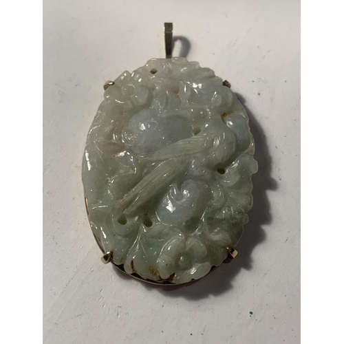 740A - A 9 CARAT GOLD AND CARVED JADE PENDANT IN A PRESENTATION BOX