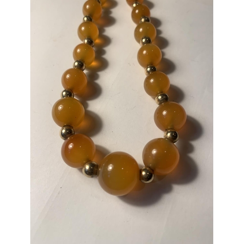 884 - A MARKED 9 CARAT GOLD AND MILK AMBER GOLD NECKLACE WITH A PRESENTATION BOX