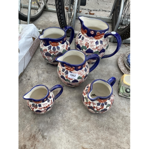 1952 - A SET OF FIVE GRADUATED FLORAL CERAMIC JUGS