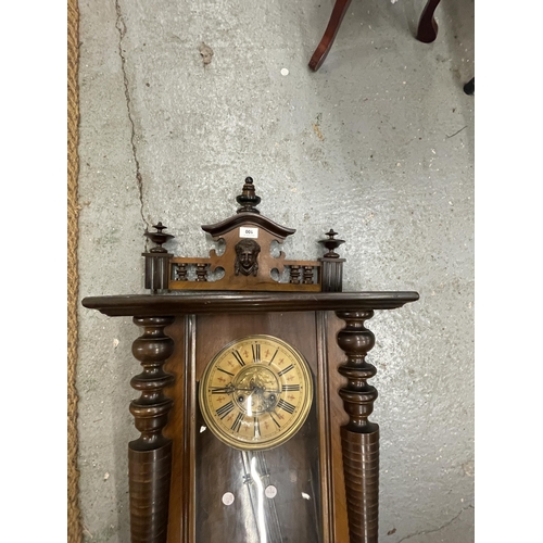 100 - A CARVED WALNUT VIENNA WALL CLOCK WITH ROMAN NUMERALS AND PENDULUM