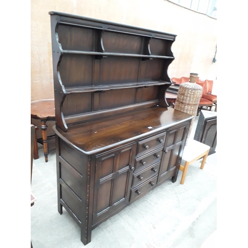 2932 - AN ERCOL COLONIAL DRESSER ENCLOSING FOUR DRAWERS AND TWO CUPBOARDS TO THE BASE, COMPLETE WITH PLATE ... 