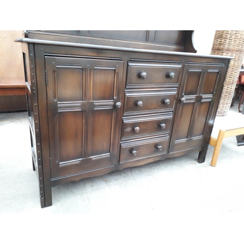 2932 - AN ERCOL COLONIAL DRESSER ENCLOSING FOUR DRAWERS AND TWO CUPBOARDS TO THE BASE, COMPLETE WITH PLATE ... 