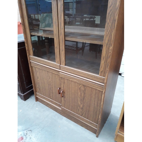 2939 - A MODERN OAK EFFECT TWO DOOR GLAZED BOOKCASE WITH CUPBOARDS TO THE BASE, 36