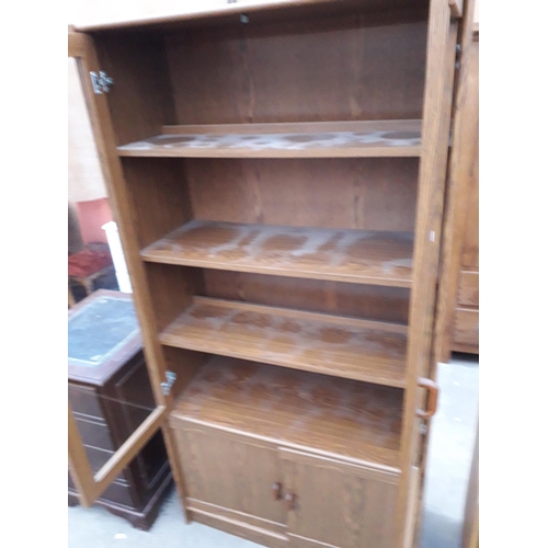 2939 - A MODERN OAK EFFECT TWO DOOR GLAZED BOOKCASE WITH CUPBOARDS TO THE BASE, 36