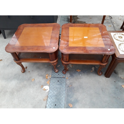 2969 - A PAIR OF BURR WALNUT LAMP TABLES WITH CANE MAGAZINE SHELF