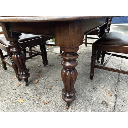 2976 - AN OVAL MAHOGANY DINING TABLE WITH TWO EXTRA LEAVES AND FOUR DINING CHAIRS (INCLUDING ONE CARVER)