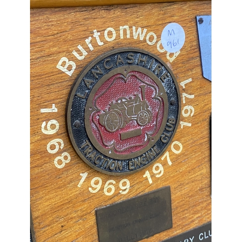 1506 - A WOODEN BOARD DISPLAYING A LARGE QUANTITY OF COMMEMERATIVE BRASS PLAQUES FROM VARIOUS STEAM RALLIES