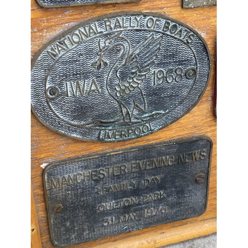 1506 - A WOODEN BOARD DISPLAYING A LARGE QUANTITY OF COMMEMERATIVE BRASS PLAQUES FROM VARIOUS STEAM RALLIES