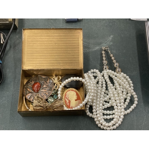 136 - A VINTAGE BRASS BOX WITH CONTENTS OF COSTUME JEWELLERY BROOCHES AND A NECKLACE