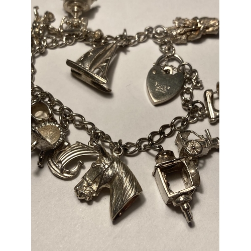 122 - A SILVER CHARM BRACELET WITH FOURTEEN CHARMS