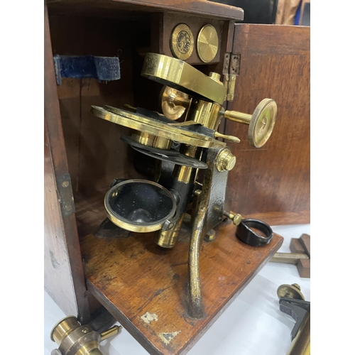 7 - A VINTAGE BRASS MICROSCOPE IN AN OAK BOX WITH A DRAWER OF SLIDES AND TWO FURTHER FITMENTS