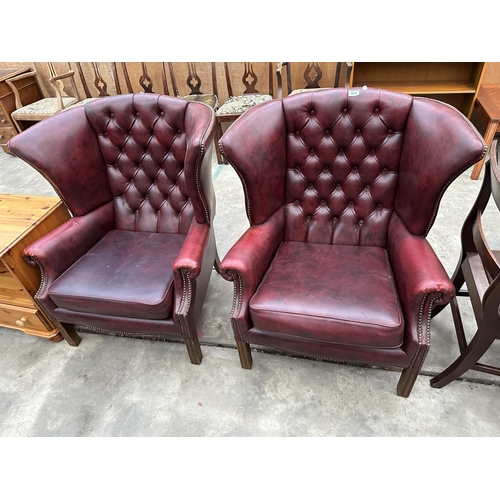 2878 - A PAIR OF MODERN BUTTON-BACK WINGED OXBLOOD FIRESIDE CHAIRS