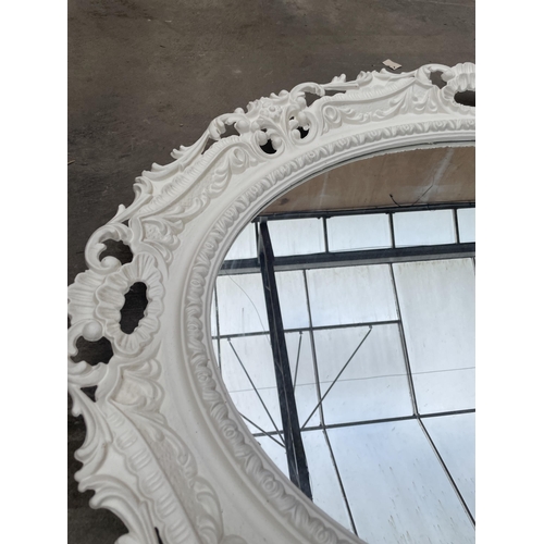 2890 - A WHITE PAINTED OVAL VICTORIAN STYLE WALL MIRRORM WITH FOLIATE DECORATION, 36 X 28