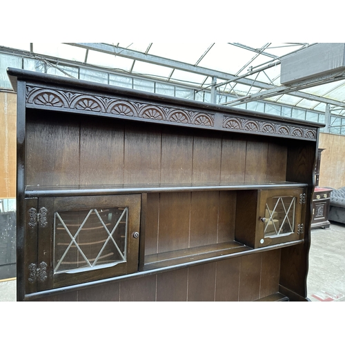 2903 - A REPRODUCTION DRESSER WITH PLATE RACK ENCLOSING TWO GLAZED AND LEADED DOORS, 49