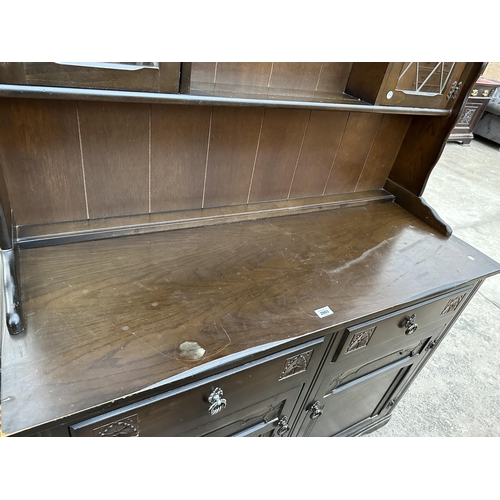 2903 - A REPRODUCTION DRESSER WITH PLATE RACK ENCLOSING TWO GLAZED AND LEADED DOORS, 49