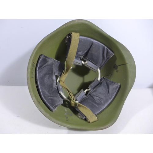 302 - A GREEN PAINTED METAL MILITARY HELMET AND LINING