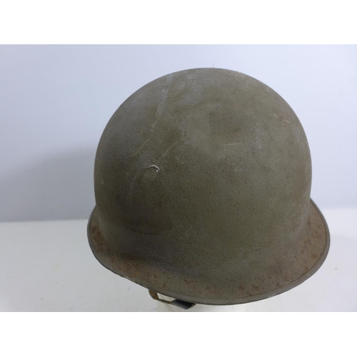 304 - A GREEN PAINTED METAL MILITARY HELMET AND LINING