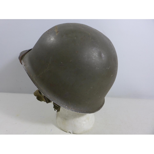 305 - A GREEN PAINTED METAL MILITARY HELMET AND LINING