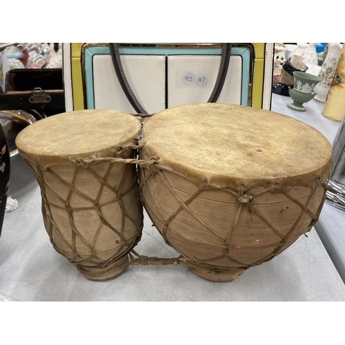 165 - A SET OF TWO ANIMAL HIDE AFRICAN DRUMS