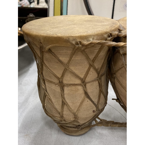 165 - A SET OF TWO ANIMAL HIDE AFRICAN DRUMS