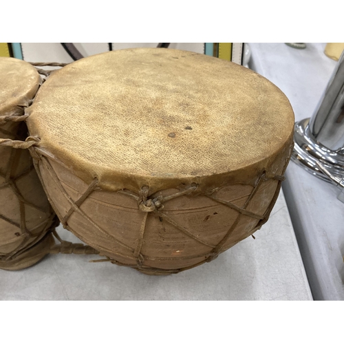 165 - A SET OF TWO ANIMAL HIDE AFRICAN DRUMS