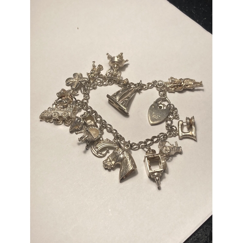 584A - A SILVER CHARM BRACELET WITH FOURTEEN CHARMS