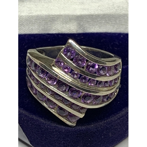 589 - A SILVER AND AMETHYST COLOURED RING IN A PRESENTATION BOX