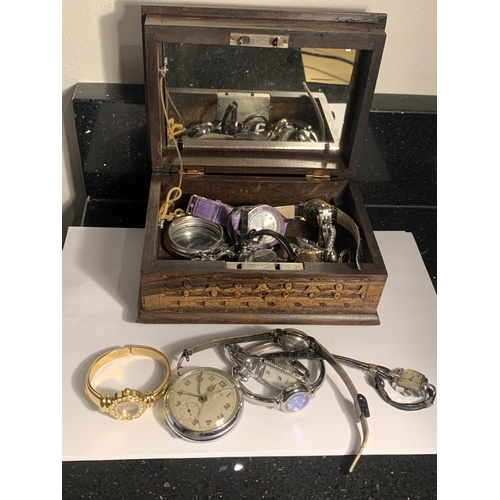 1009 - A CARVED WOODEN BOX WITH A QUANTITY OF WATCHES AND PARTS