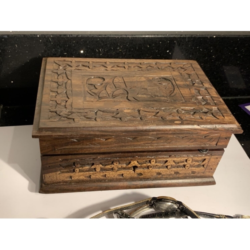 1009 - A CARVED WOODEN BOX WITH A QUANTITY OF WATCHES AND PARTS