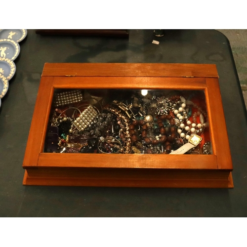 101 - A QUANTITY OF COSTUME JEWELLERY IN A GLASS TOPPED DISPLAY CASE