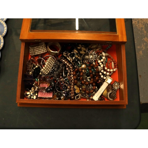 101 - A QUANTITY OF COSTUME JEWELLERY IN A GLASS TOPPED DISPLAY CASE