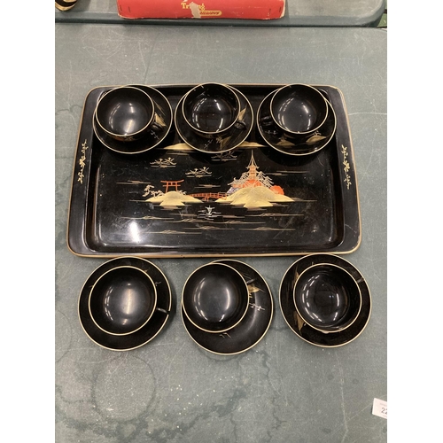 220 - AN ORIENTAL HANDPAINTED, LACQUERED TRAY WITH SIX CUPS AND SAUCERS