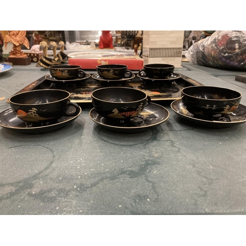 220 - AN ORIENTAL HANDPAINTED, LACQUERED TRAY WITH SIX CUPS AND SAUCERS