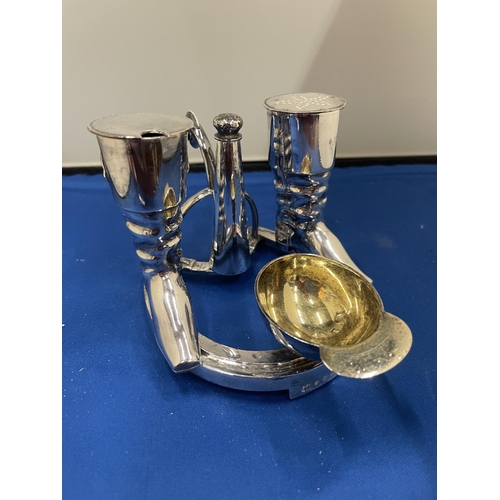 65 - AN ELKINGTON SILVER PLATED CRUET SET IN THE GUISE OF RIDING BOOTS AND HAT ST ON A HORSE SHOE BASE