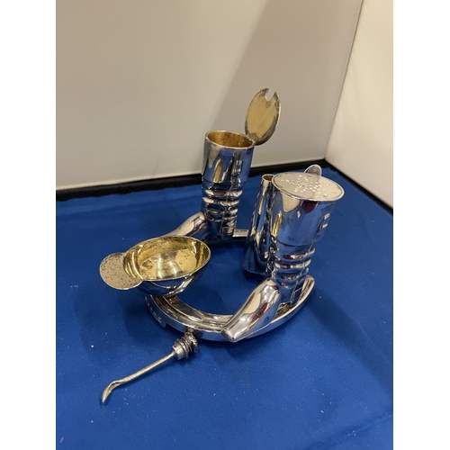 65 - AN ELKINGTON SILVER PLATED CRUET SET IN THE GUISE OF RIDING BOOTS AND HAT ST ON A HORSE SHOE BASE