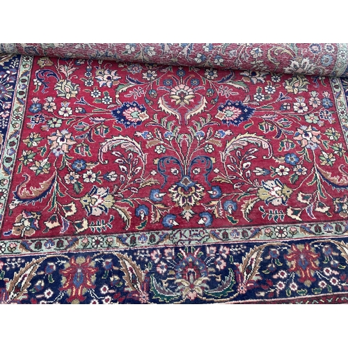 2493 - A LARGE RED PATTERNED FRINGED RUG