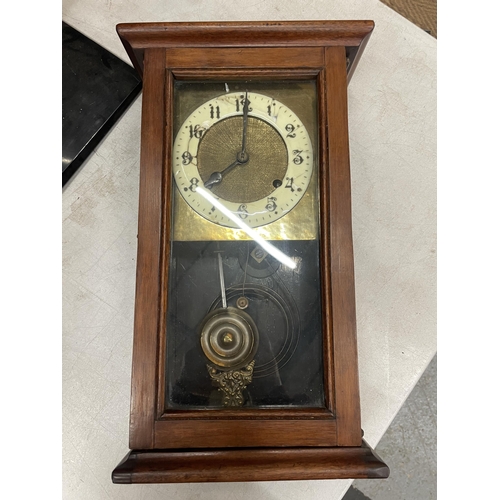 59 - AN OAK CASE CHIMING WALL CLOCK