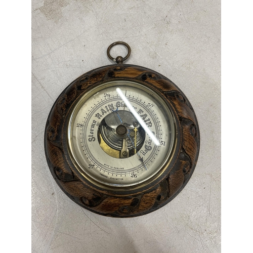 60 - A CIRCULAR BAROMETER WITH A CARVED FRAME