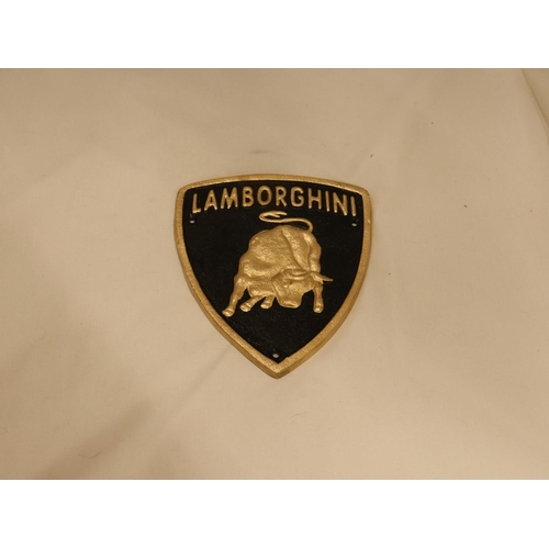 123 - A TRIANGULAR BLACK AND GOLD CAST METAL LAMBORGHINI SIGN, 21CM X 18CM