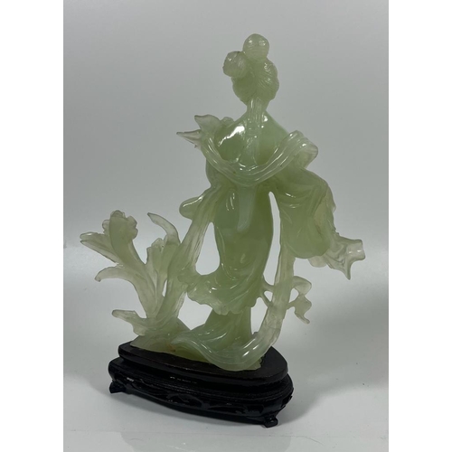 302 - A VINTAGE JADEITE JADE TYPE FIGURE ON A WOODEN DISPLAY BASE, HEIGHT 23 CM