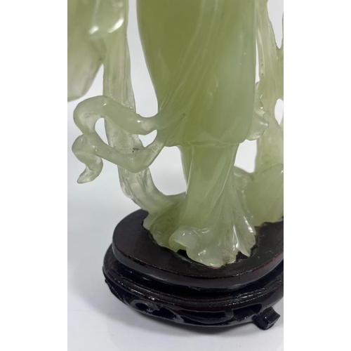 302 - A VINTAGE JADEITE JADE TYPE FIGURE ON A WOODEN DISPLAY BASE, HEIGHT 23 CM